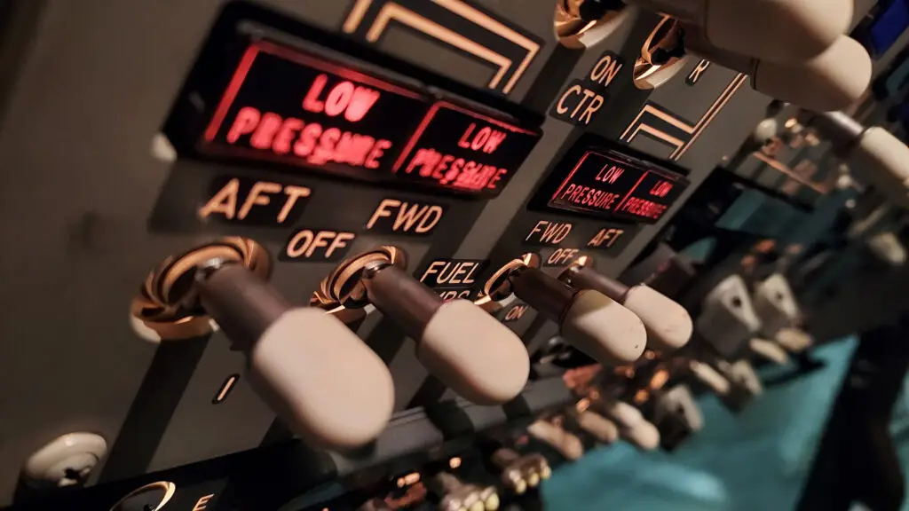 Close-up of the Boeing 737 NG flight deck fuel pump switches, showing illuminated low pressure warnings and labeled AFT, FWD, and CTR positions.